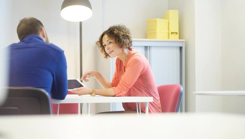 two people talking under a lamp on a table fishers in